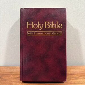New International Version (NIV) Holy Bible with a burgundy hardcover.